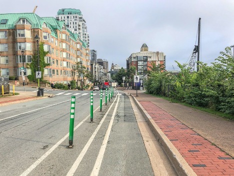 Alt Text: A bike lane protected by barriers preventing vehicles from entering it.